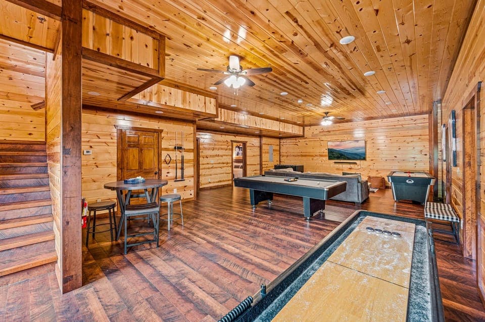 Game room features a sitting area, pool table, foosball, and shuffleboard.