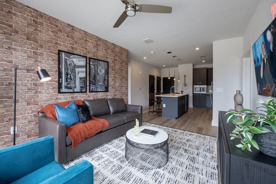 Inviting designer furnished living space featuring a comfortable sleeper sofa, a Smart TV for entertainment and a private covered balcony.