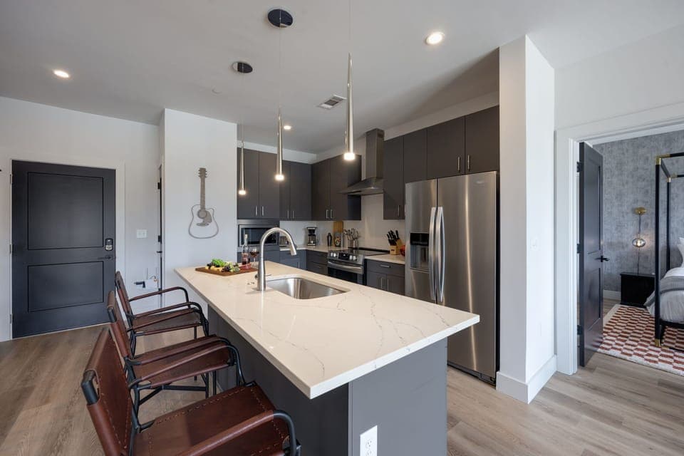Fully equipped modern kitchen boasting brand-new stainless-steel appliances and stocked with all culinary essentials for ease and convenience. Kitchen island offers ample counter space and bar seating.