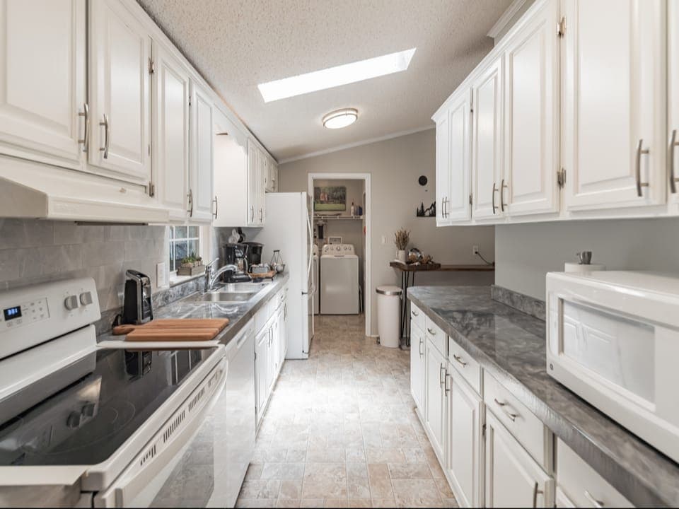Spacious kitchen- many extras-airfryer, instapot, crockpot, microwave, blender, mixer, coffee grinder, spices. Stocked with cookware and dinnerware. Coffee station