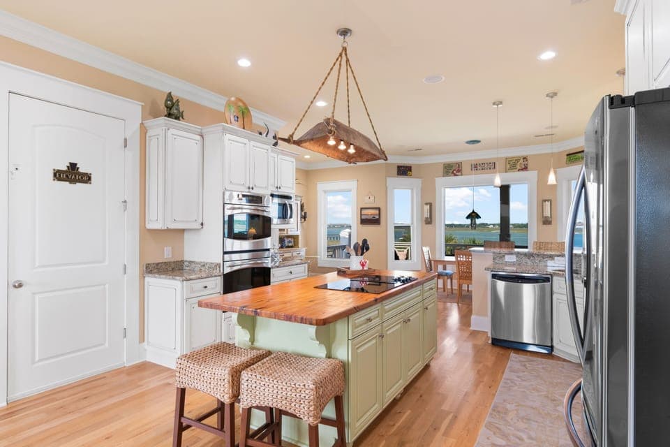 Your gourmet kitchen features granite counters, warm hardwood floors, and water views beyond—perfect for cooking memorable meals.