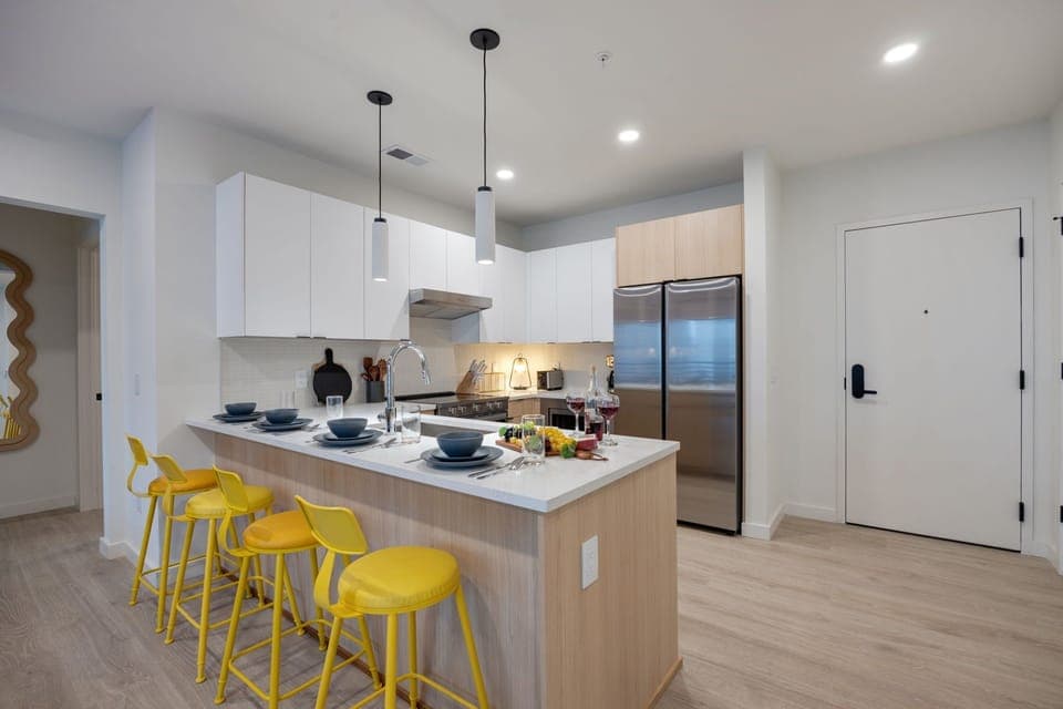 Fully equipped modern kitchen stocked with all culinary essentials and featuring stainless steel appliances with island bar seating.