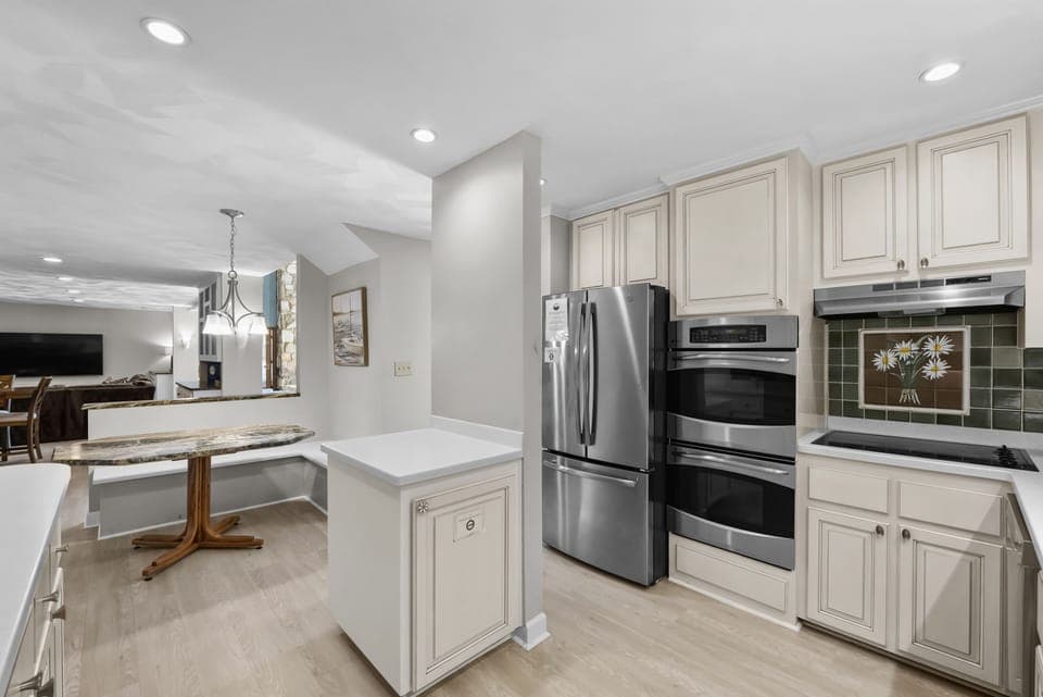Kitchen features new appliances, double ovens.