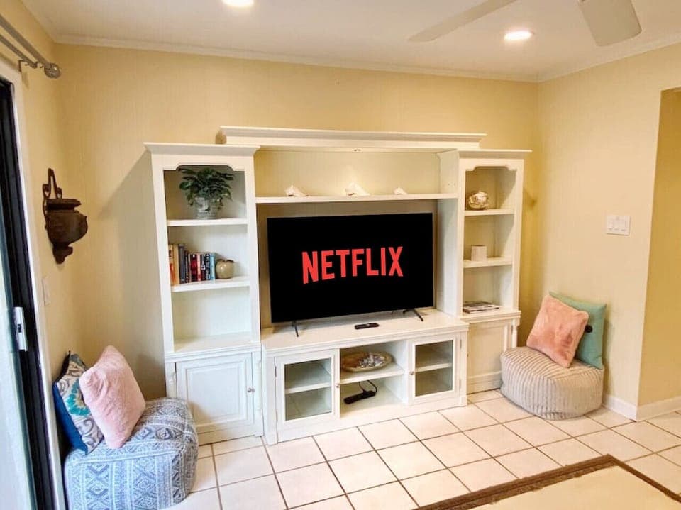 Cozy up and enjoy your favorite Netflix shows on a 55` TV, or unwind with a good book in this inviting entertainment space!