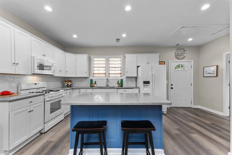 Updated and fully-equipped kitchen with granite countertops. Additional seating for two at bar. 