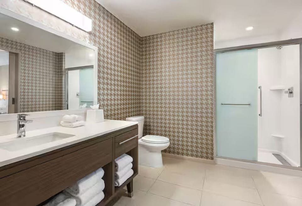 Refresh in a spotless bath with bright vanity lighting.