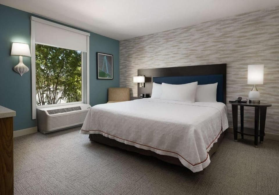 Relax into crisp linens beside a peaceful, leafy view.