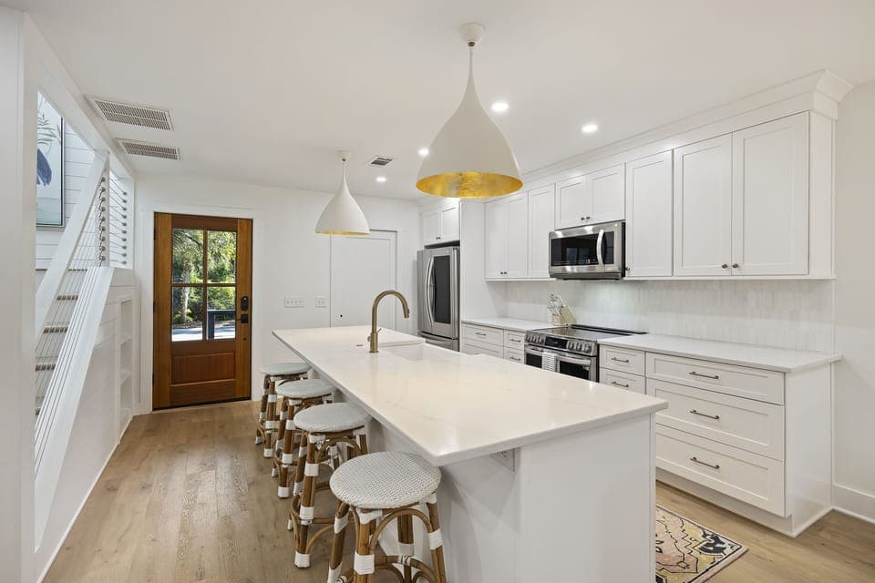 Renovated fully-equipped kitchen with large central island and new appliances, cabinetry and countertops.