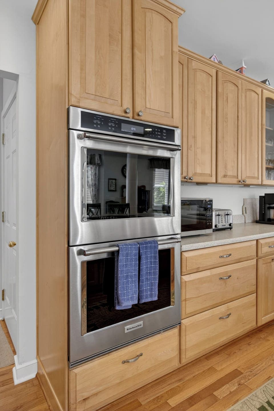 Cook your favorite meals in this fully-equipped kitchen with double ovens and warm wood cabinetry.