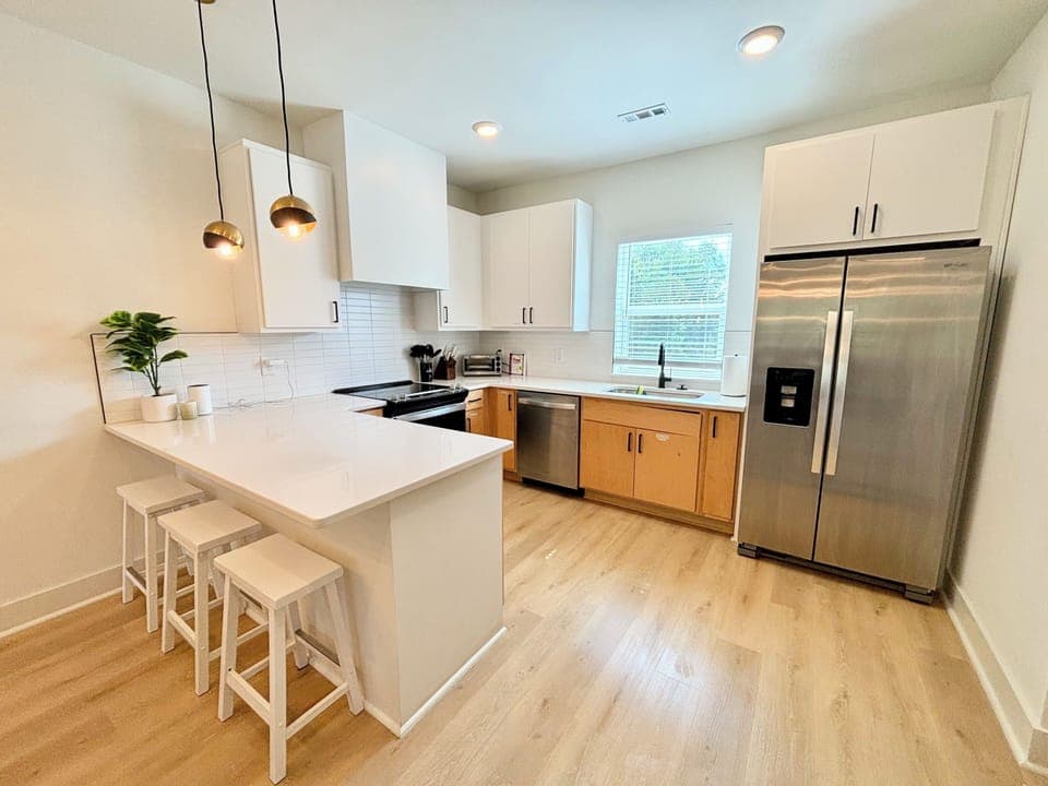 KITCHEN - The kitchen boasts a modern, clean design with stainless steel appliances and ample counter space. Perfect for cooking and entertaining in a comfortable, open setting.