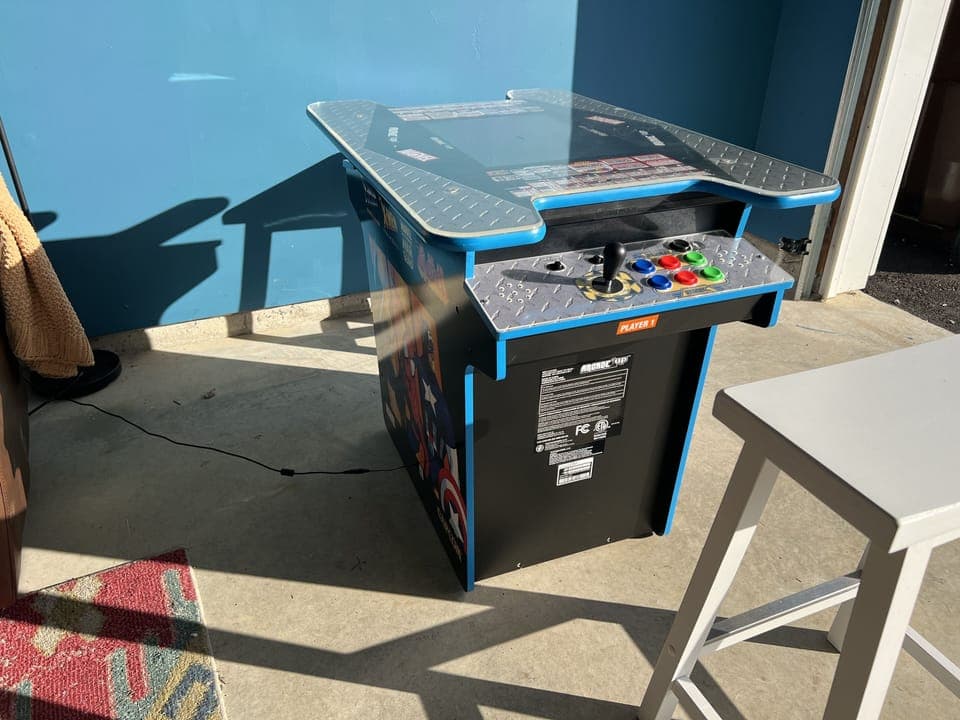 GAME ROOM ARCADE GAME - The ultimate garage game room, where fun and relaxation come together! This space is packed with entertainment, featuring a basketball game, classic arcade game, and a comfortable sofa to kick back and watch your favorite shows on the 40" television. A large drink fridge keeps beverages chilled and easily accessible, while an ice maker ensures you’re alw...