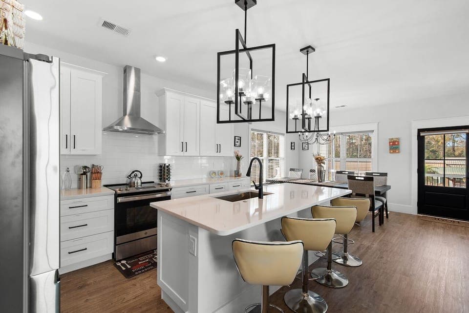 Your gourmet kitchen awaits with pristine white cabinets, gleaming quartz island, and stylish pendant lighting perfect for cooking.
