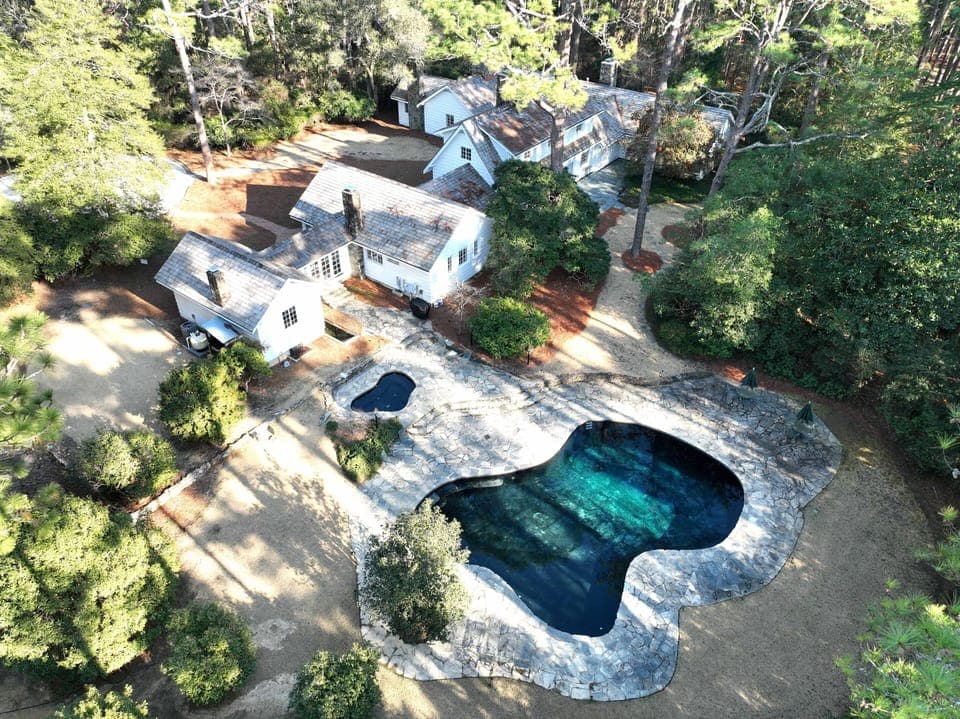 Drone shot above the backyard, pool and hot tub are kidney shaped