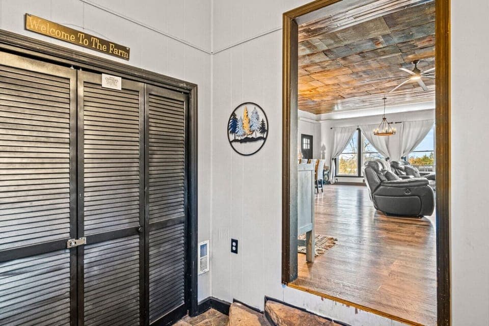 The entrance to the farmhouse. Hooks are located in the entryway for coats/jackets and there is also a bench.