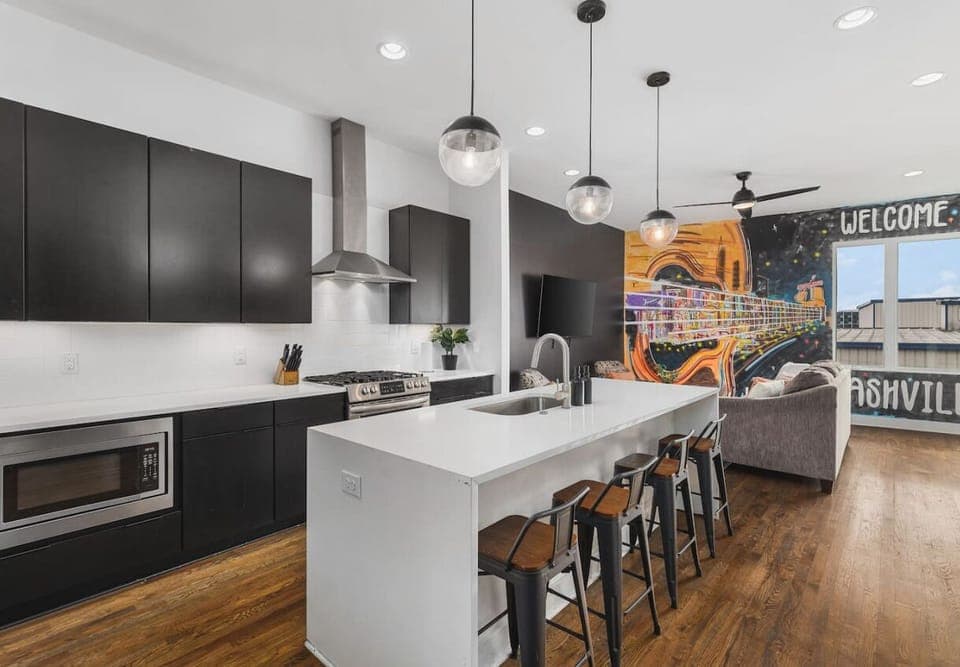 Fully-stocked chef's kitchen with a gas range, wet bar, seating for four at the island, and all the appliances / tools you could need to cook and enjoy a meal together.