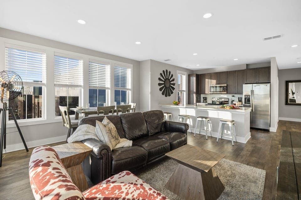 Bright open floor living space featuring a smart flat-screen TV, designer furnishings, and dining room table.