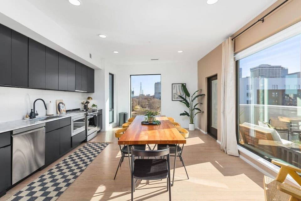 Fully-stocked kitchen and beautiful dining table with seating for 8. The door on the right leads to your private patio overlooking the city.