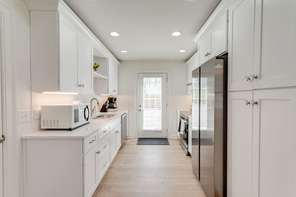 The kitchen has a door that leads to the backyard.