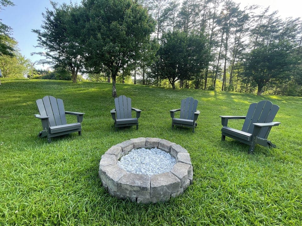 Outdoor fire pit with Adirondack chairs.