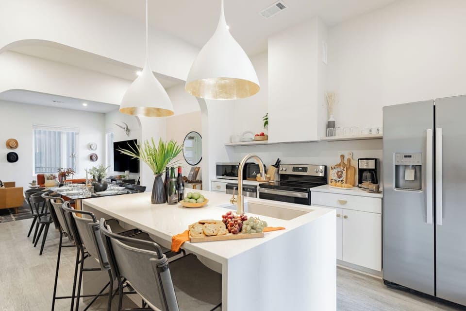 Moder, fully equipped kitchen features an island and stainless steel appliances.