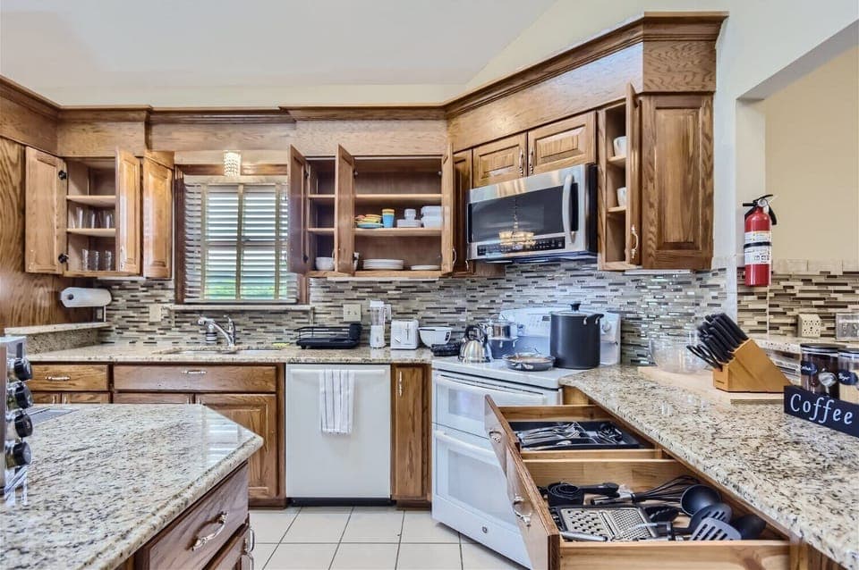 Enjoy the full kitchen with filtered water, refrigerator, freezer, oven, stove, microwave, dishwasher, coffee, creamers, mixers, spices, pots, pans, cooking supplies, cutlery, cups, plates, bowls, utensils, small appliances, and many more essentials!
