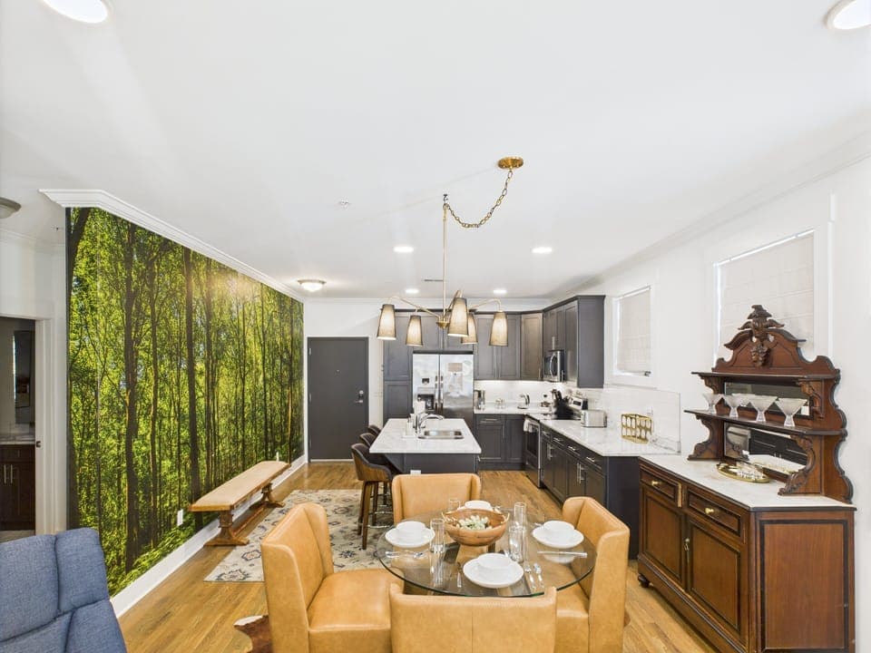 The dining area features a table for four and a hutch with cocktail-making utensils and drinkware to unwind after a day of exploring. Overlooks the warm and inviting living room.
