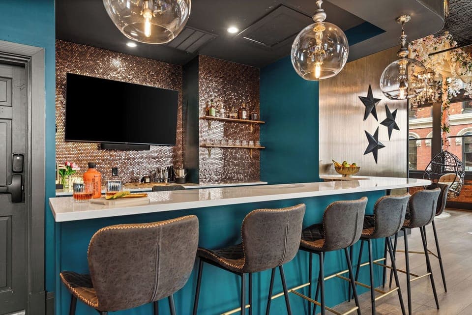 - High-top bar seating with bold décor and chic pendant lights   - Sleek counter, warm tones and star accents elevate the area   - Fun gathering space perfect for drinks, laughs and conversation