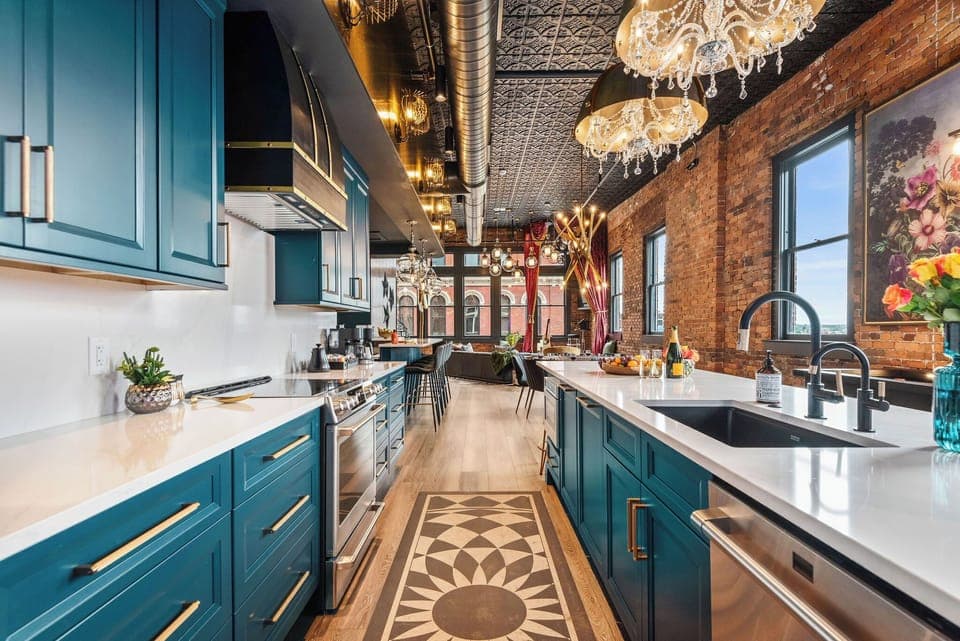 - Modern kitchen with blue cabinets and chic lighting   - Spacious countertops and full appliances ready for cooking   - Beautiful open-concept space with bright natural light