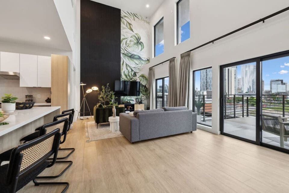 Bright 2-story condo with an open-concept kitchen + living room, space for Murphy beds, and huge windows for natural light. Plus a full downstairs bathroom—perfect for groups and easy, comfortable stays!