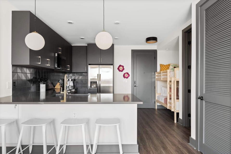 Clean and Spacious Kitchen with Sleek Countertops and Additional Seating
