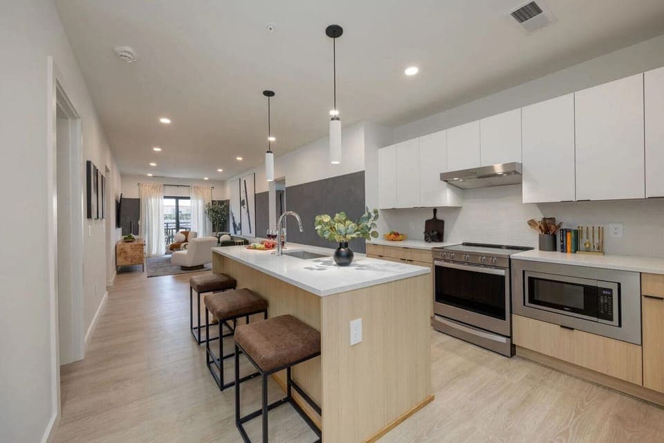 Unit 2: Kitchen stocked with all culinary essentials and fully equipped with brand-new stainless-steel appliances. Features an island with bar seating.