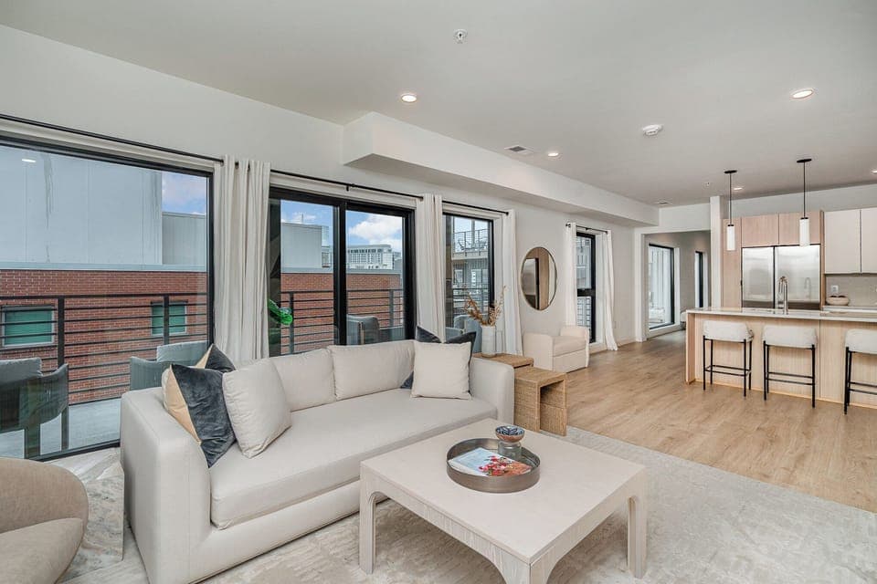 Unit 1: Bright open living space featuring Samsung Frame Smart TV, designer furnishings, and access to private patio.