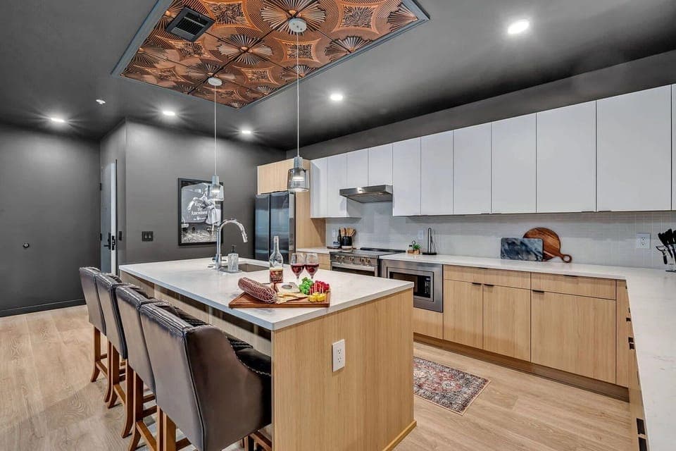 Unit 2: The fully equipped modern kitchen features culinary essentials, stainless steel appliances, and island bar seating.