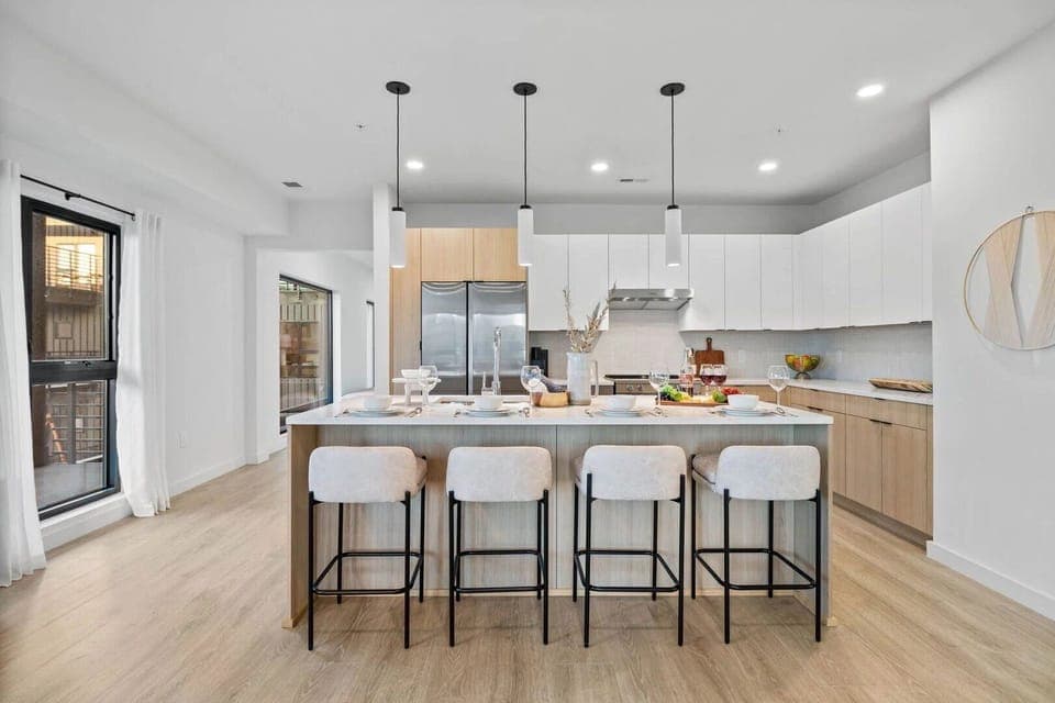 Unit 1: Fully equipped modern kitchen featuring culinary essentials, stainless steel appliances, and island bar seating.