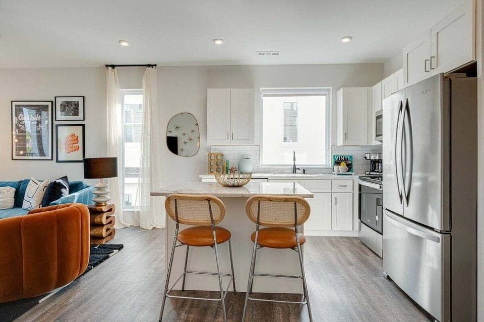 5623 - Bright and open kitchen equipped with stainless steel appliances and is fully stocked with your basic cooking essentials. Features breakfast bar seating and connects to living space.