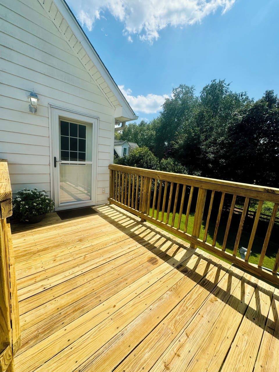 Private deck with 2 seats and small table overlooking the pool area 