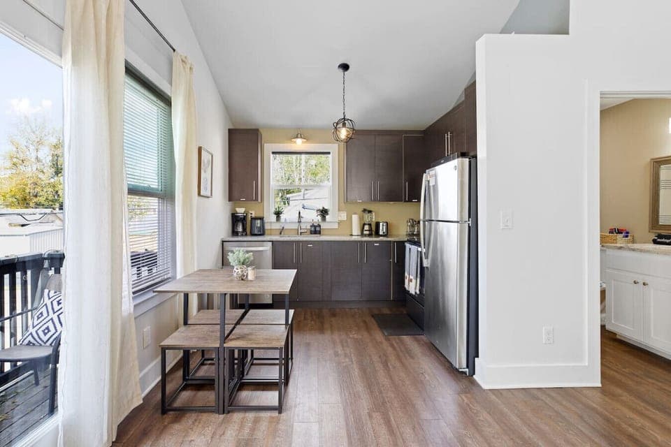 Bright kitchen with stainless steel appliances, coffee station, and a dining nook overlooking the balcony 🍳☕🌿