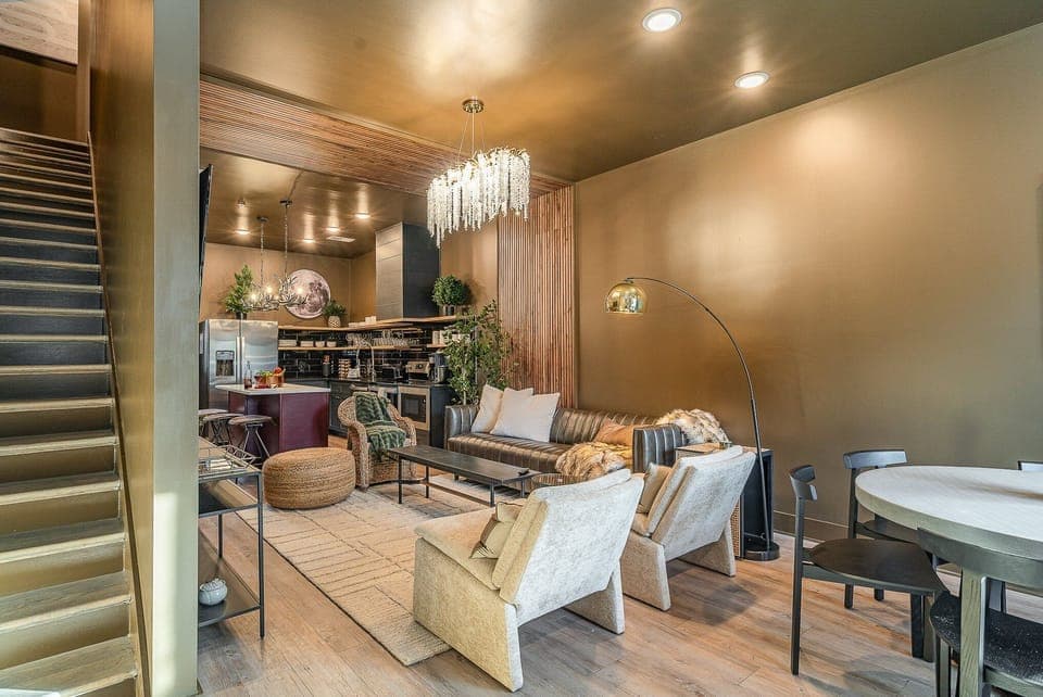 Bright, open living area with a smart flat-screen TV and stylish designer furnishings seamlessly connecting the dining area and kitchen. (1st Floor)