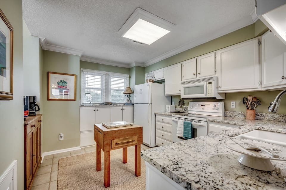 Step into the charming chef’s kitchen with sleek granite countertops, ample storage, and a craft butcher block—perfect for your next culinary creation.
