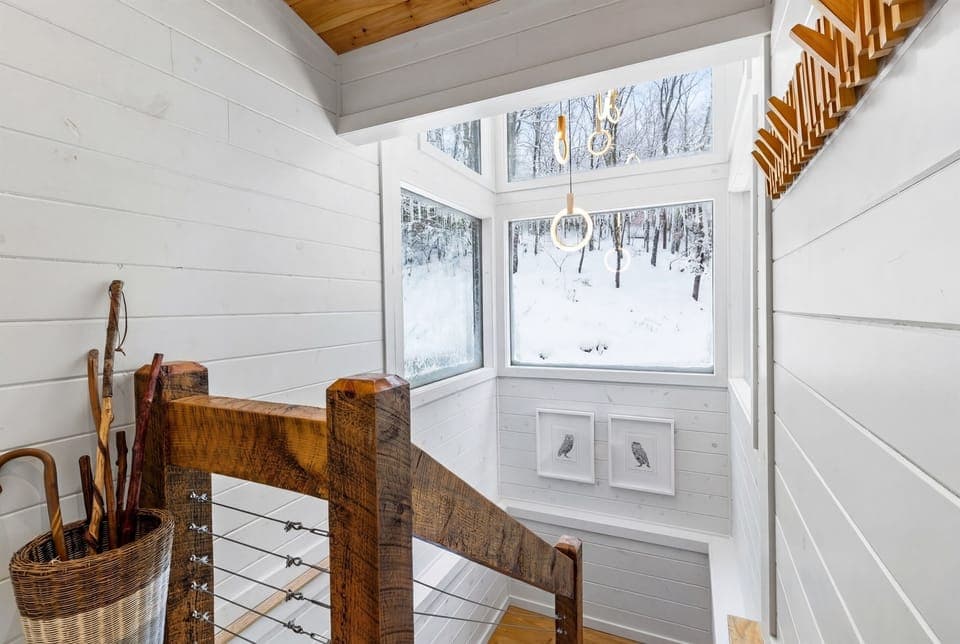 Enjoy the convenience of interior stairs, a unique feature setting this modern cabin apart from others. With sleek design elements, large windows, and artistic touches, this stairwell combines style and functionality, offering seamless access to all levels