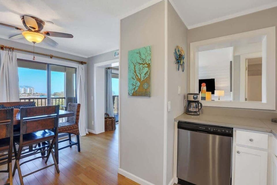 A living room offering views of the surrounding trees and nearby buildings.