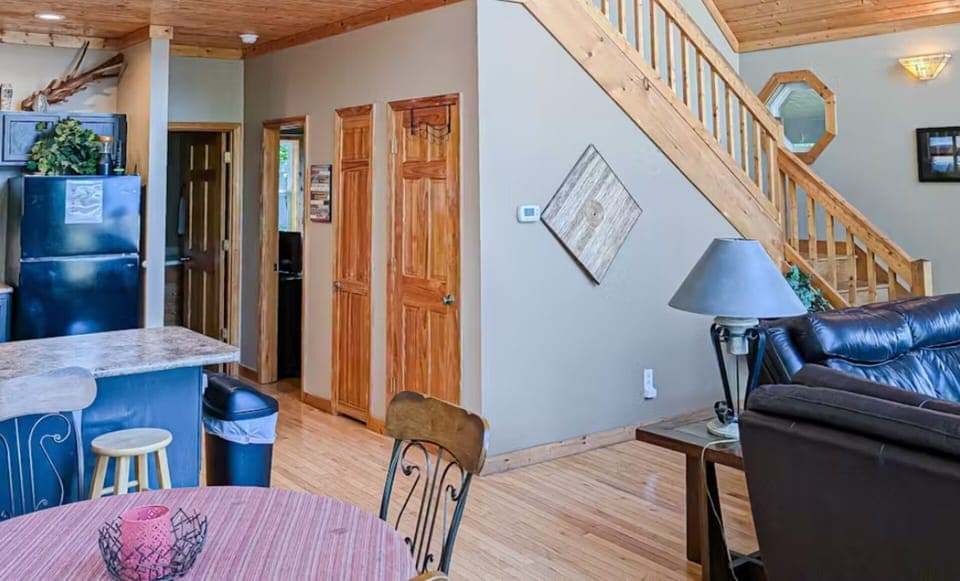 Rustic wood staircase and open dining space at this Alarka, NC vacation rental near Nantahala outdoor adventures