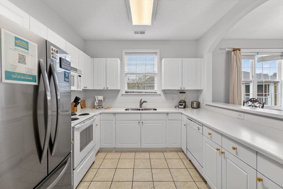 Clean, bright kitchen with full-size appliances and everything needed for cooking at home.