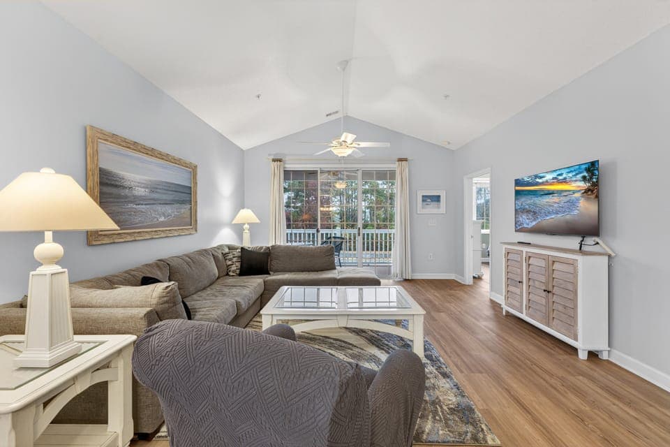 Spacious living area with vaulted ceilings, natural light, and comfortable seating for relaxing or gathering.