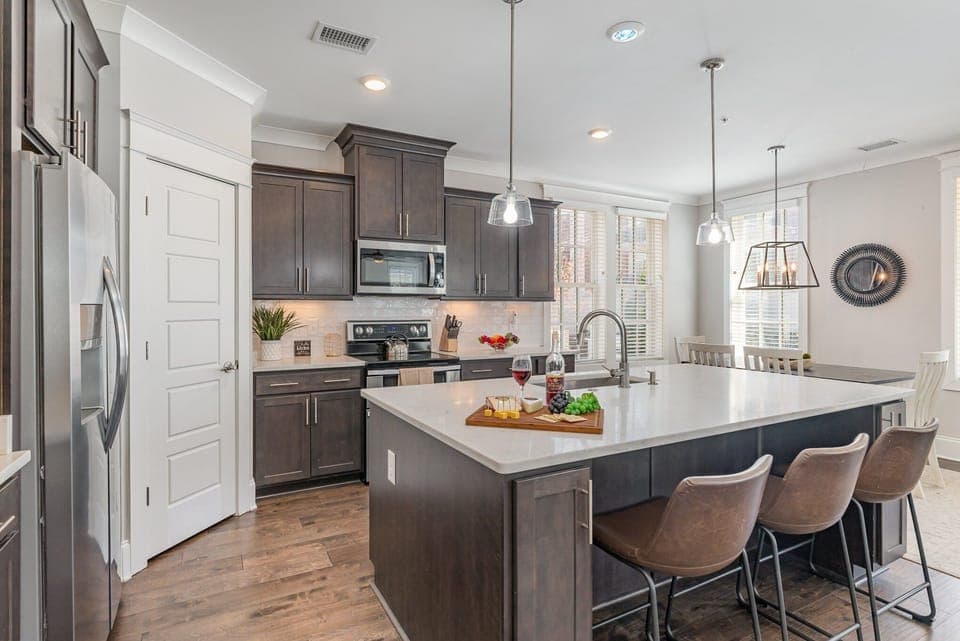 Unit 1 (1st Floor): Fully equipped kitchen stocked with all culinary essentials, stainless steel appliances and an island offering bar seating for 3 guests.