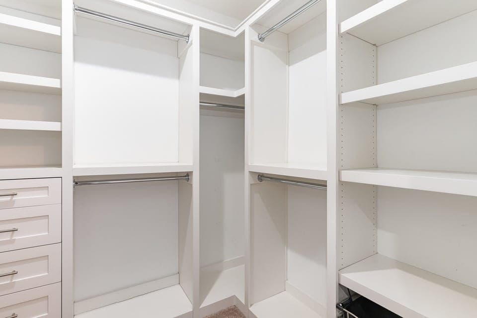 Unit 1: Primary Bathroom featuring a dual vanity with a stand-in shower, shower/tub combo, and walk-in closet.