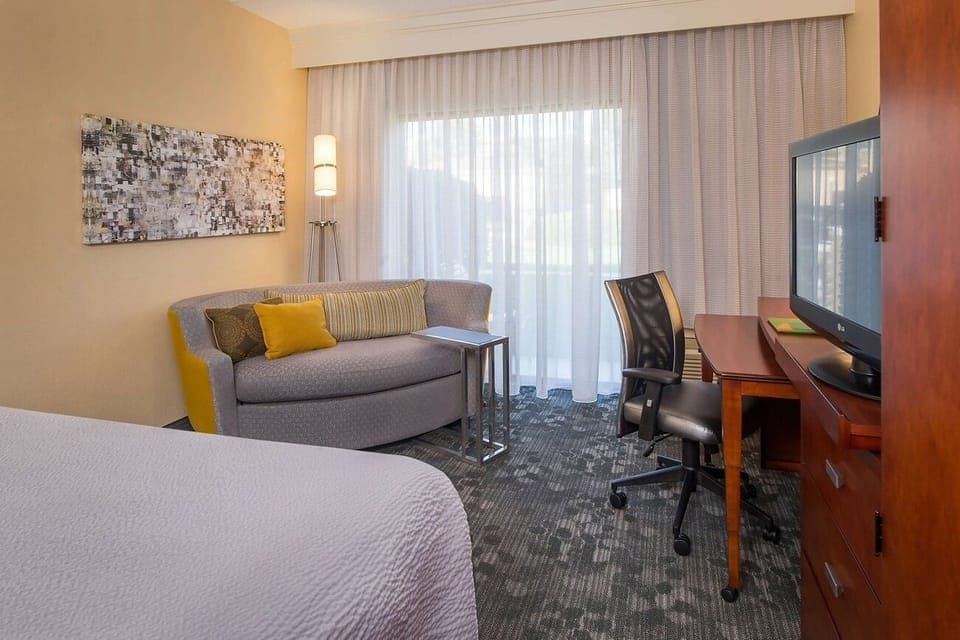 Unwind in a bright room with sofa, desk, and TV.