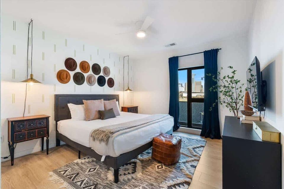 Primary Bedroom: King bed with stunning city views, designer furnishings and en-suite bathroom. Bathroom includes a dual vanity and shower/tub combo.