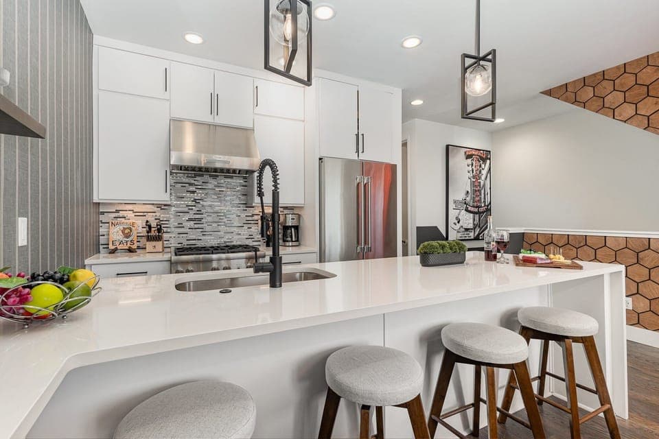 2nd Floor: Fully equipped kitchen with stainless steel appliances and a kitchen island with seating for 4 guests.