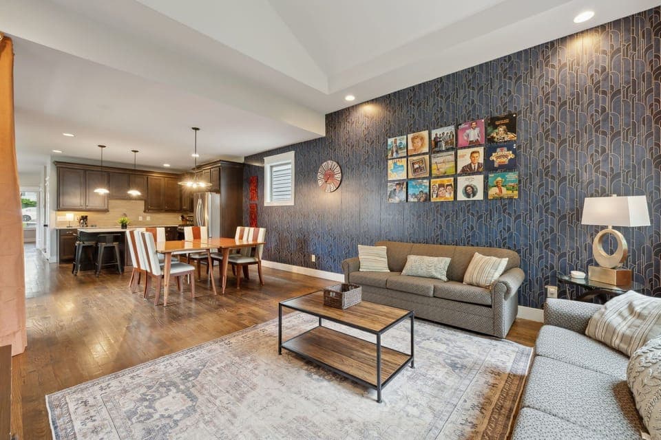 Living Room: Unit A - Unwind on comfy couches, framed by striking Art Deco wallpaper and retro vinyl art. Style meets comfort in every corner.